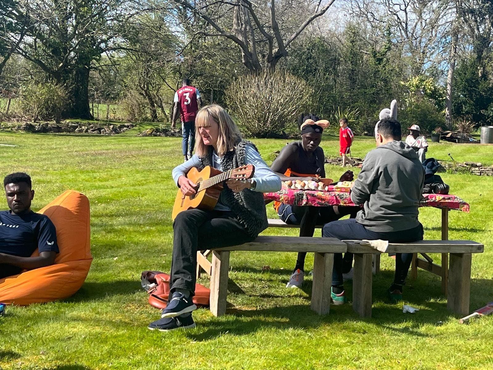 Gitarrenspiel an einer Picknickbank auf dem Rasen