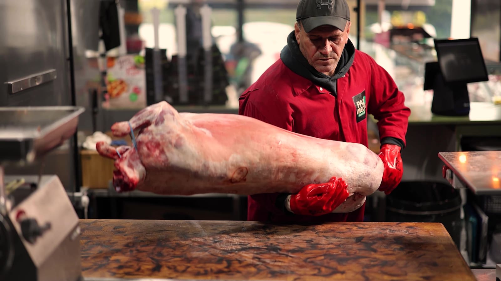 A butcher lifting a lamb carcass onto the block
